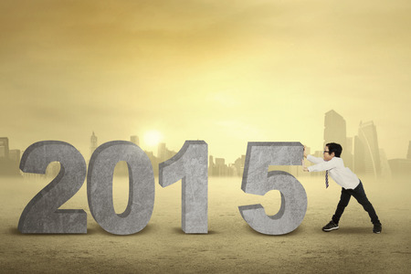 Schoolboy pushing number 2015, symbolizing new year 2015 is comingの写真素材