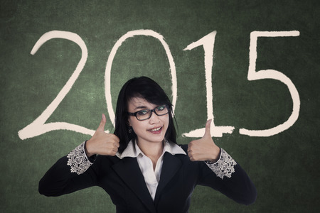 Attractive asian businesswoman showing thumbs up with a text of 2015の写真素材
