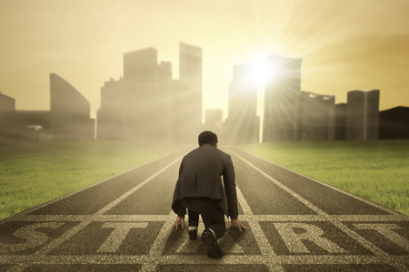 Rear view of business person in ready position on start line to compete