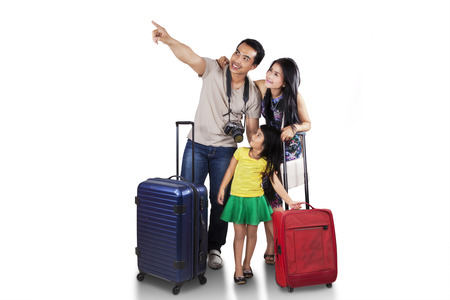 Portrait of happy family carrying suitcase for holiday and looking at copyspaceの写真素材