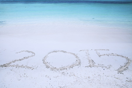 New year 2015 is coming concept. Handwriting of number 2015 on sand at tropical beach