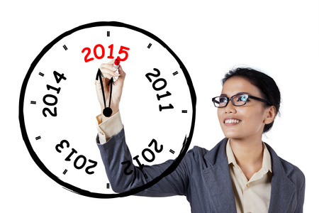 Young businesswoman makes annual clock with number 2012, 2013, 2014, 2015