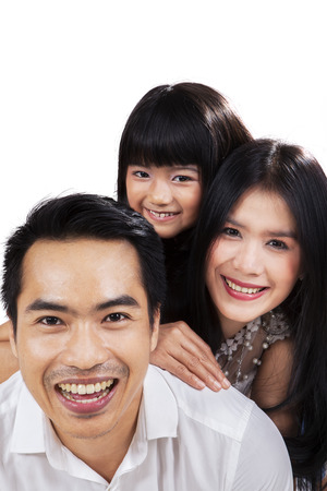 Portrait of happy little family smiling on camera in studioの写真素材
