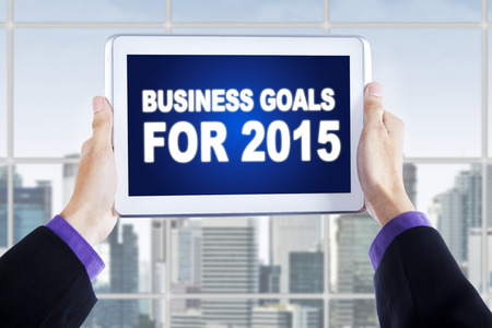 Entrepreneur hands holding a digital tablet with a text of business goals for 2015の写真素材