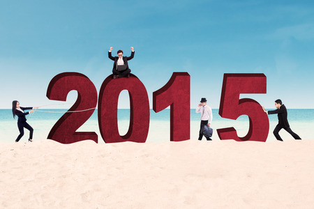 Group of business people arrange number 2015 on beachの写真素材