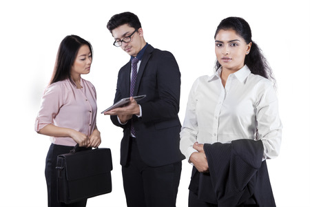 Confident businesswoman holding business suit and looking at the camera with her team on the backの写真素材