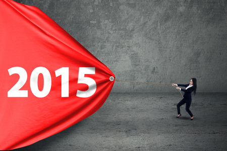 Hispanic entrepreneur try to pull number 2015 on banner, symbolizing a changeの写真素材