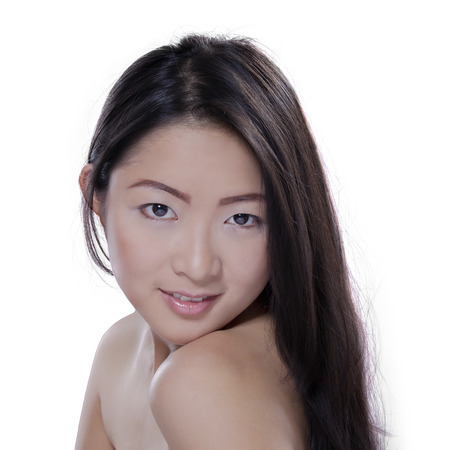 Attractive young asian model in studio with smooth skin and long black hair, isolated on whiteの写真素材