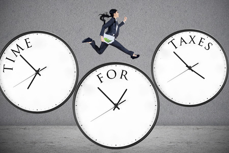 Concept of time for taxes with a businesswoman running on watchの素材 [FY31036025689]