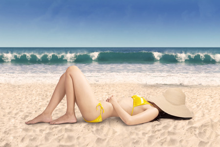 Sexy woman in bikini relaxing on beach, shot on tropical beachの写真素材
