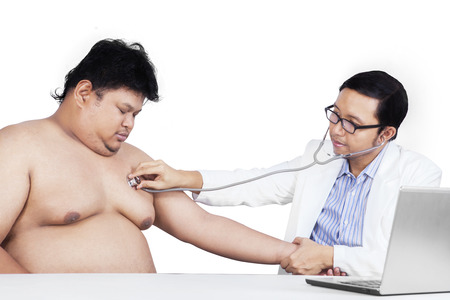 Portrait of fat person doing checkup with his doctor, isolated on whiteの写真素材