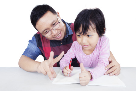 Portrait of young father helping his daughter for doing homework and learn to count with her finger, isolated on whiteの写真素材