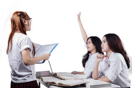 Female high school student raising her hands for asking on her friend, isolated on white backgroundの写真素材