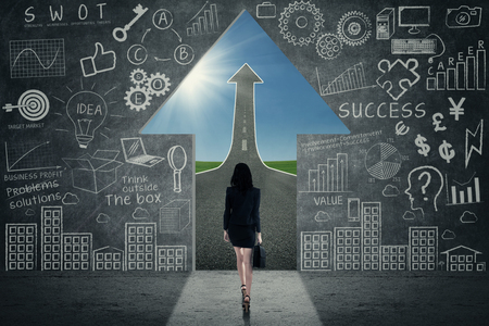 Opportunity concept - Business woman walking towards opportunity doorの写真素材