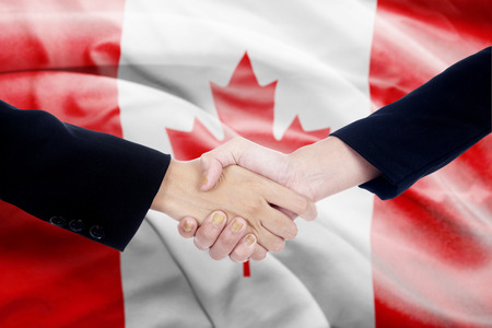 Two politicians shaking hands in front of canada flag backgroundの写真素材