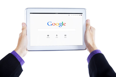 JAKARTA, SEPTEMBER 09, 2015: Image of entrepreneur hands holding tablet computer with google...