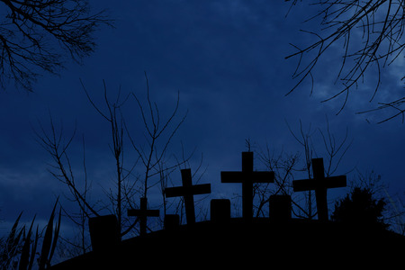 Silhouette of graveyard in the dark of halloween night with full moonlightの写真素材