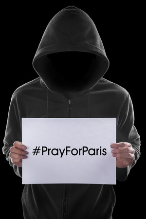 Anonymous person holding a piece of paper with #prayforparis printed on itの写真素材