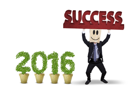 Image of businessman lifting a success text with plants shaped numbers 2016 on the pot