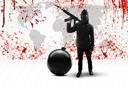 Terrorism concept: Male terrorist standing in front of a background of bloody world map while...