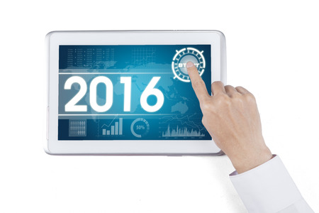 Hand touching digital tablet with the economic forecast for 2016