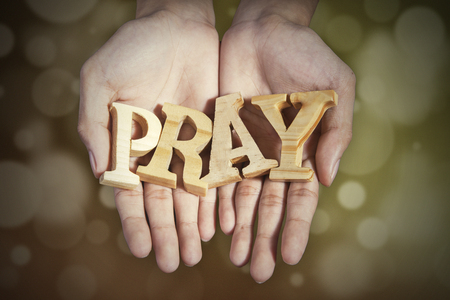 Image of two prayer hands holding a word of pray with bokeh backgroundの写真素材