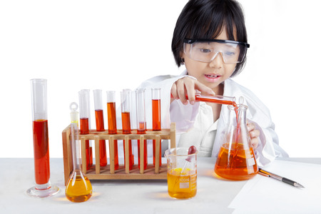 Portrait of little schoolgirl wearing lab coat and doing research, isolated on white backgroundの写真素材