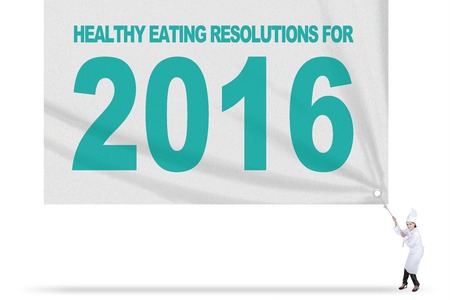 Image of Indian female chef wearing uniform and pulls banner of healthy eating resolutions for 2016