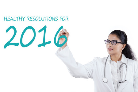 Image of Indian female doctor writes healthy resolutions for 2016 on the whiteboard, isolated on...