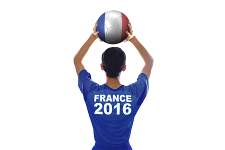 Backside of football player of Euro 2016 France wearing soccer costume and lifting a ball in the studioのeditorial素材