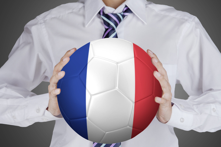 Close up of businessman holding a soccer ball with France flag in the studio.の写真素材