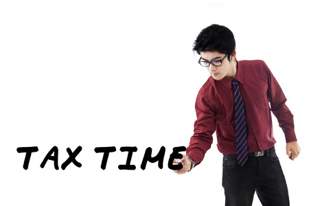 Businessperson writes a tax time on whiteboard to remind the time for pay tax duty, isolated on whiteの写真素材
