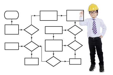 Little boy wearing helmet and drawing empty flow chart while standing in the studio, isolated on white backgroundの写真素材