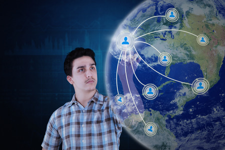 Social network concept. Young Arabian person touching social network button on the virtual screenの写真素材