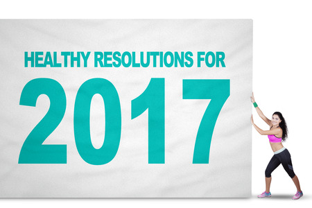 Image of a fit Indian woman pulling a big flag with text of healthy resolution and number 2017の写真素材