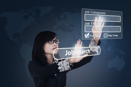 Young Asian businesswoman finding jobs online in the virtual website on futuristic screen. Concept of online job searchingの写真素材