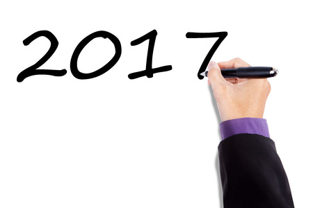 Image of hand using a pen to writing numbers 2017 on the whiteboardの写真素材