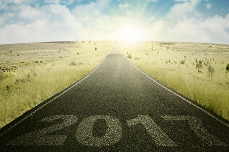 Image of an empty road towards sun with numbers 2017 on the asphalt roadの写真素材
