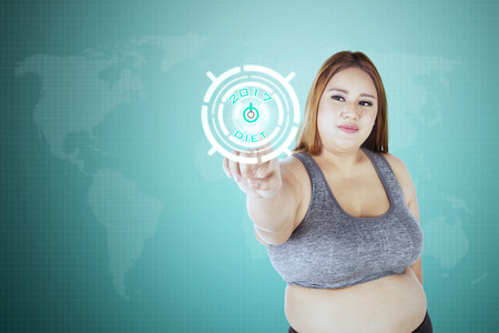 Obese woman click start button with text diet 2017 on the virtual screenの写真素材