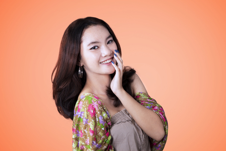 Portrait of beautiful teenage smiling at camera while posing in the studioの写真素材