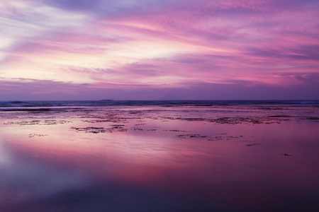 Beautiful beach view at sunset time with purple sky and reflection on the waterの写真素材