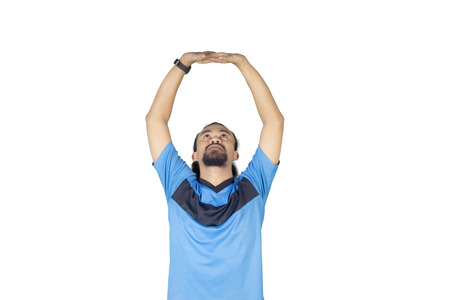 Image of Afro man stretching hands while exercising in the studio