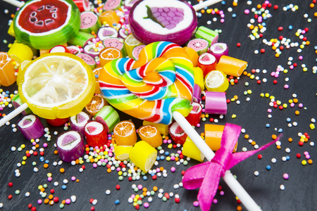 Close up of colorful fruit candies and lollipops on the wooden backgroundの写真素材