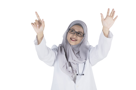 Image of pretty Muslim female doctor is touching a transparent screen, isolated on white backgroundの写真素材