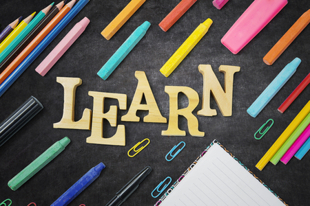 Closeup of stationery for school with learn word on the blackboardの写真素材