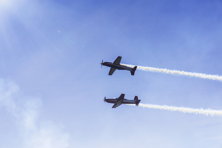 Image of two airplane flying with smoke while doing airshow in the blue sky