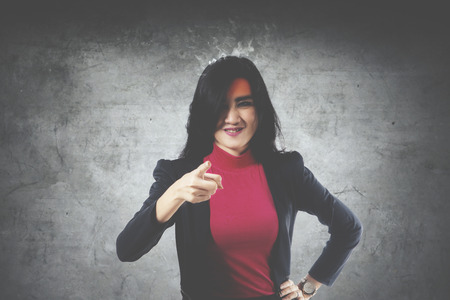 Image of Asian businesswoman looks stressful with smoke over her head while pointing at the cameraの写真素材