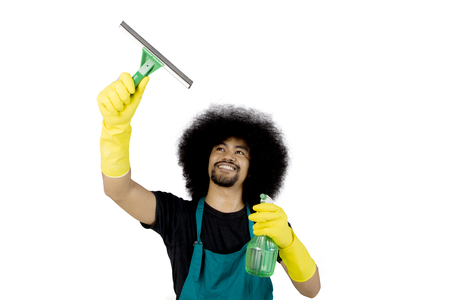 Photo of Afro maid cleaning a mirror with a spray and squeegee, isolated on white background