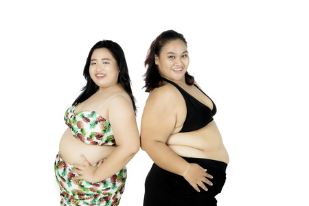 Picture of two obese women looks confident while wearing a swimsuit, isolated on white backgroundの写真素材
