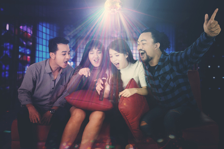 Image of diverse people are enjoying their music while singing together in the night clubの写真素材